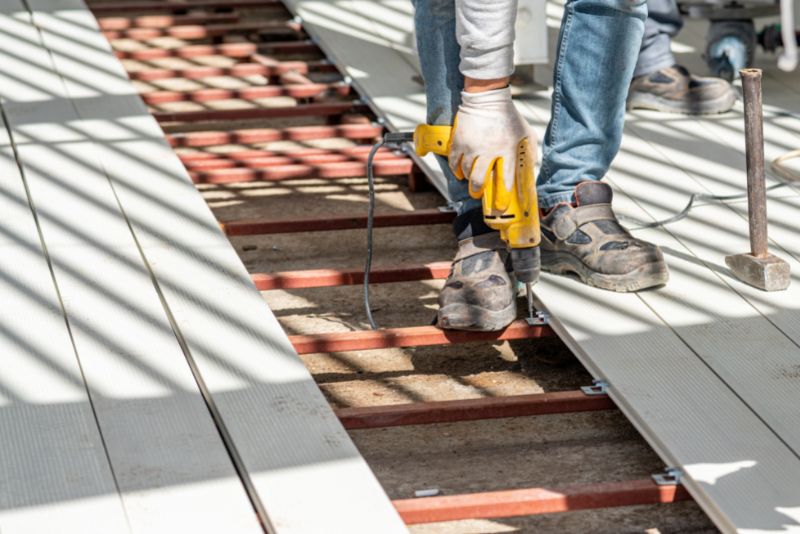 Composite decking boards being fastened into place during installation