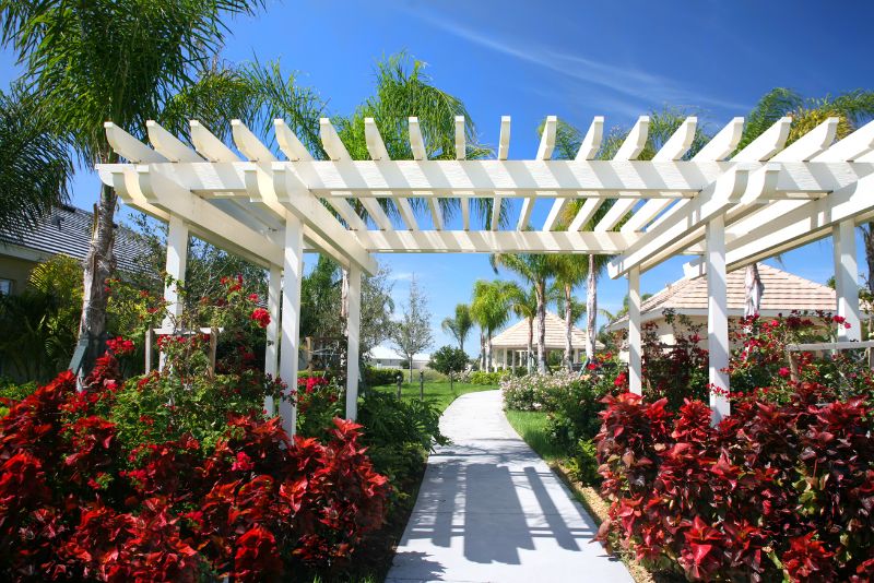 Freestanding pergola surrounded by garden flowers