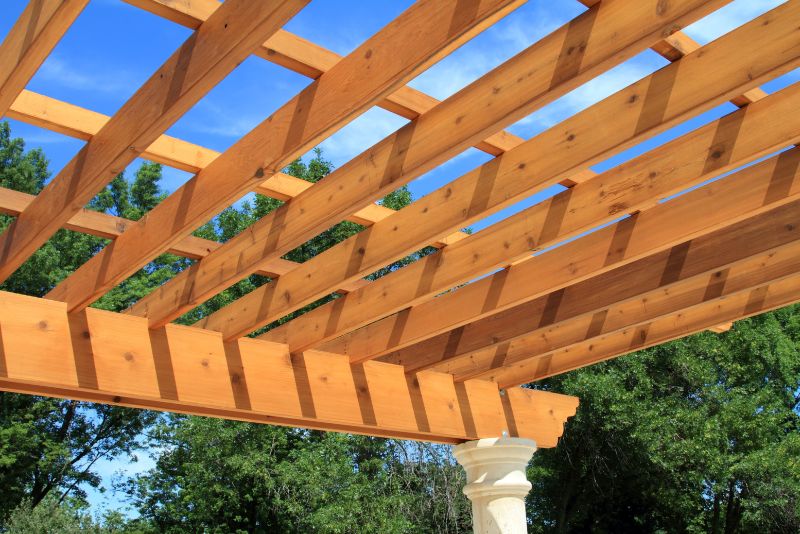 Timber pergola with a stone column against a blue sky
