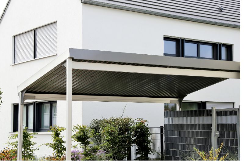 Flat-roofed carport attached to the side of a rendered house
